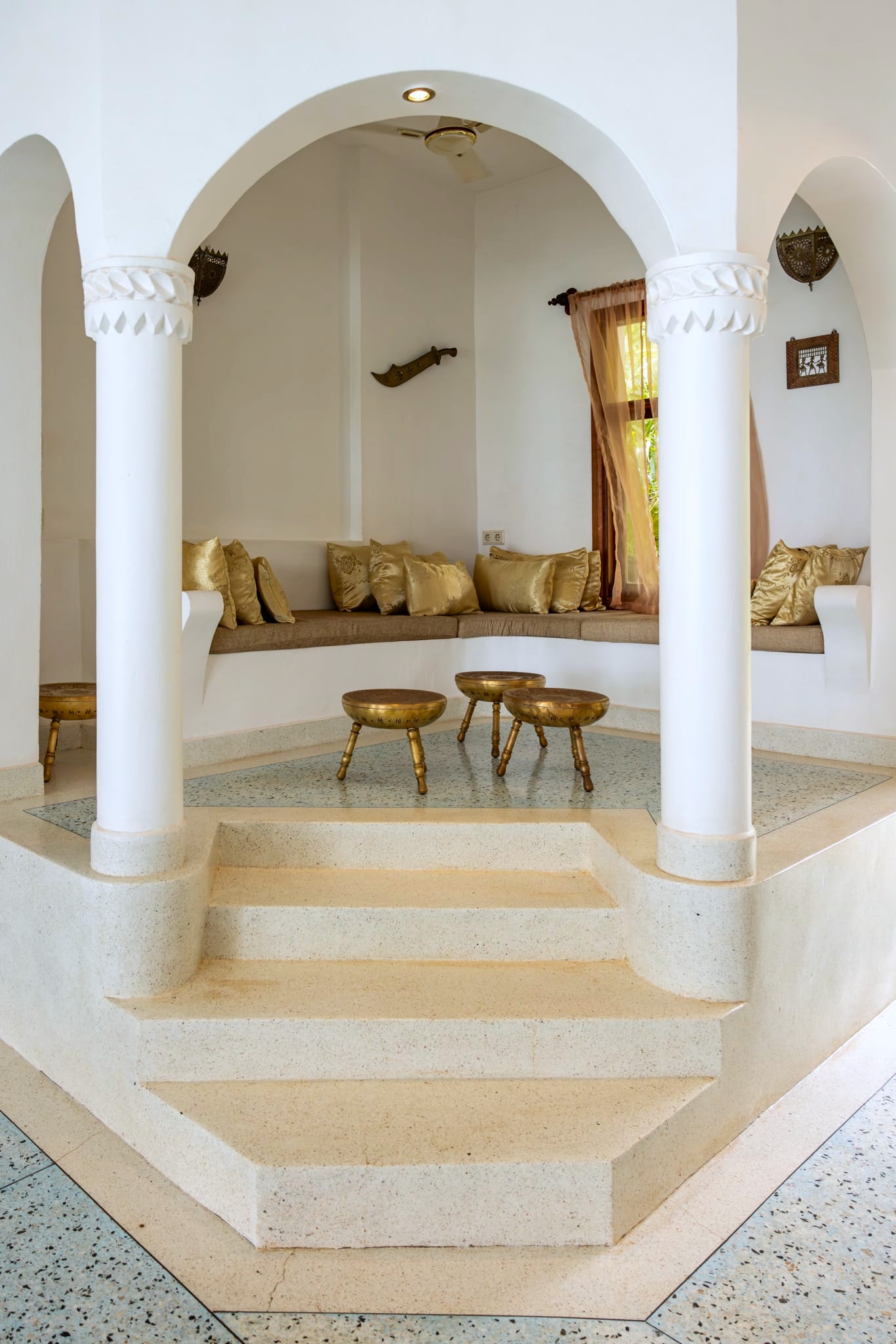 The baraza seating at Villa Kidosho: built-in benches, gold cushions, brass stools.
