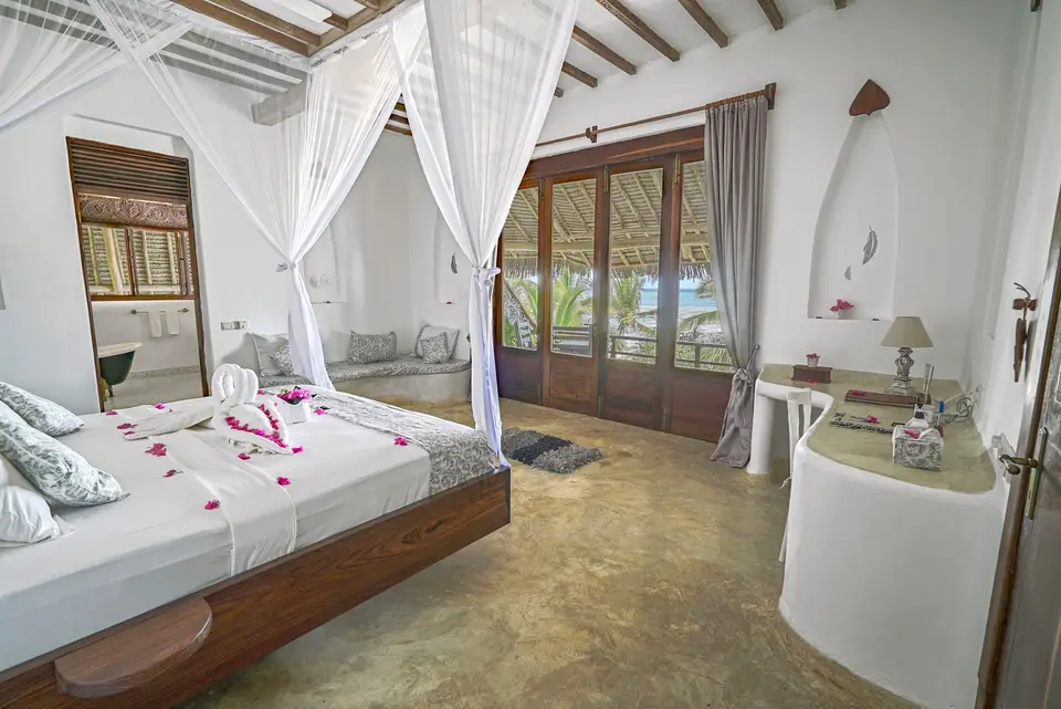 Zimmer Hewa bei Tageslicht im Asili House, Boutique Hotel Matlai Sansibar, mit Bett, Baraza-Sitzbereich und Balkon.