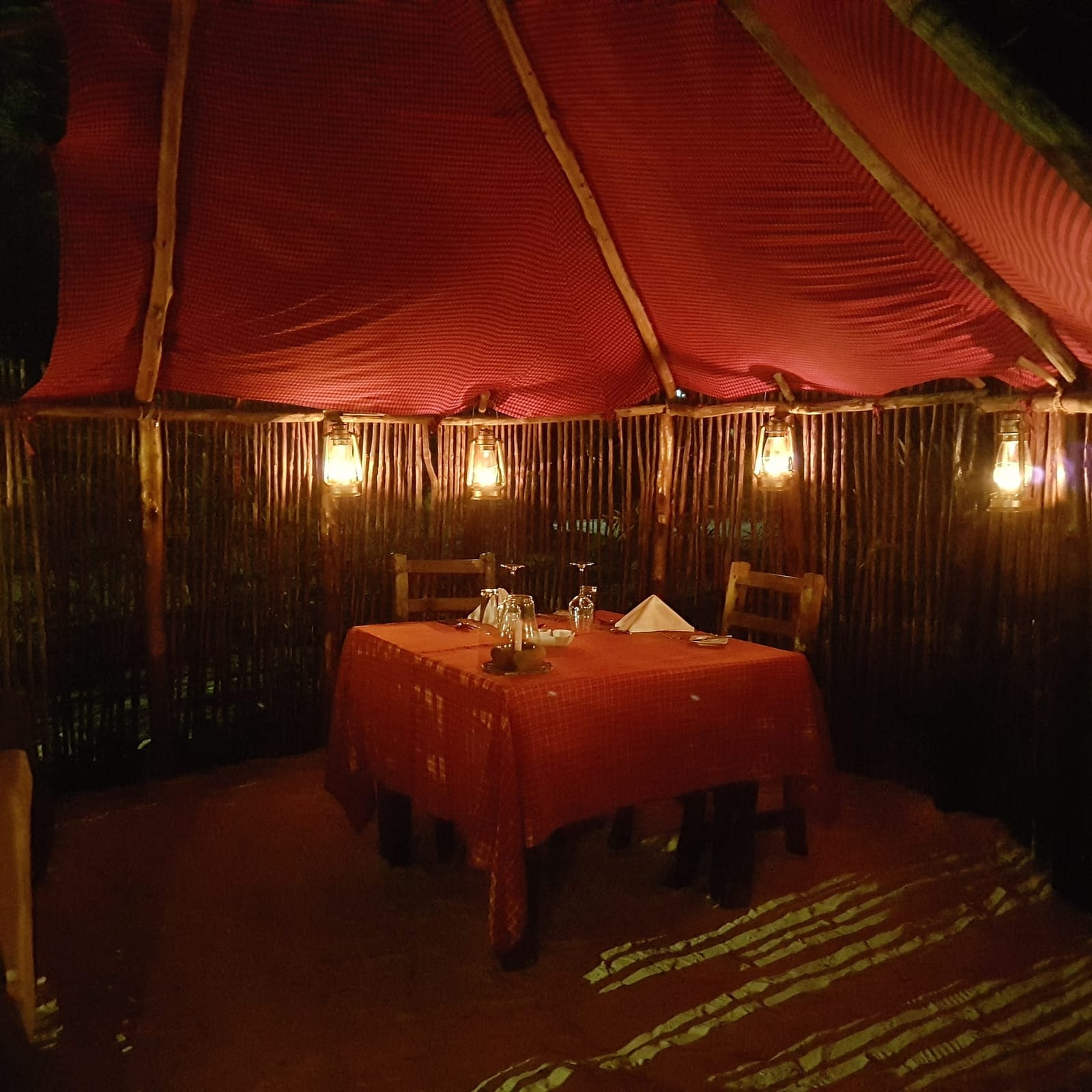 A table laid for dinner in the garden at night